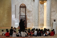 Les in de Sjeikh Zajed moskee Abu Dhabi met kinderen